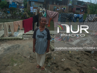 A resident is standing on the banks of the Deli River, which is polluted with plastic waste following floods, in Medan, North Sumatra, Indon...