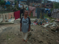 A resident is standing on the banks of the Deli River, which is polluted with plastic waste following floods, in Medan, North Sumatra, Indon...