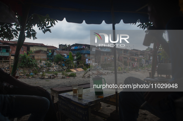 Residents are spending the afternoon on the banks of the polluted Deli River, which is contaminated with plastic waste after floods, in Meda...