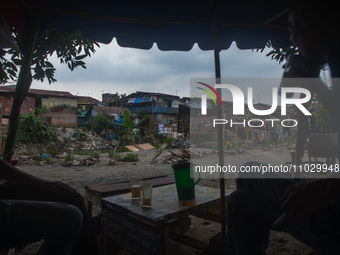 Residents are spending the afternoon on the banks of the polluted Deli River, which is contaminated with plastic waste after floods, in Meda...