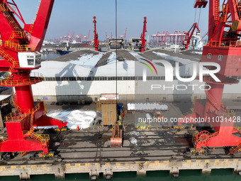 Dock workers are loading fertilizer that has been unloaded from a cargo ship at the port of Lianyungang, in Jiangsu Province, China, on Febr...