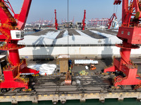 Dock workers are loading fertilizer that has been unloaded from a cargo ship at the port of Lianyungang, in Jiangsu Province, China, on Febr...