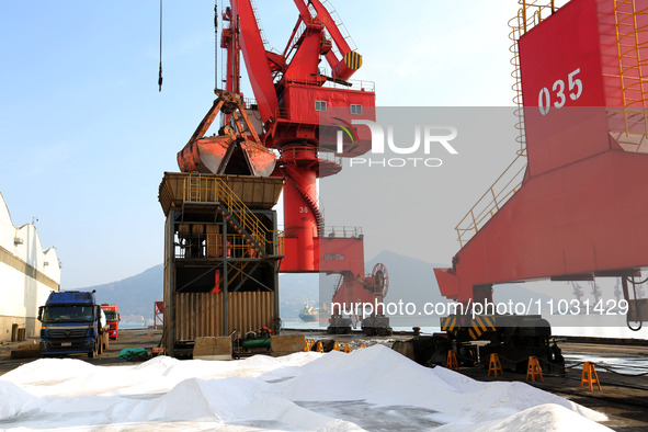 Dock workers are loading fertilizer that has been unloaded from a cargo ship at the port of Lianyungang, in Jiangsu Province, China, on Febr...