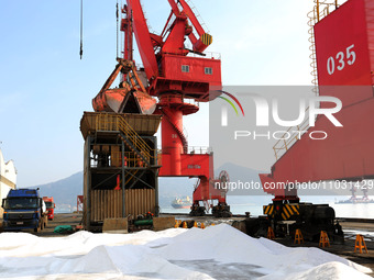 Dock workers are loading fertilizer that has been unloaded from a cargo ship at the port of Lianyungang, in Jiangsu Province, China, on Febr...