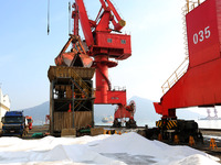 Dock workers are loading fertilizer that has been unloaded from a cargo ship at the port of Lianyungang, in Jiangsu Province, China, on Febr...