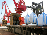 Dock workers are loading fertilizer that has been unloaded from a cargo ship at the port of Lianyungang, in Jiangsu Province, China, on Febr...