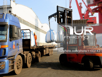 Dock workers are loading fertilizer that has been unloaded from a cargo ship at the port of Lianyungang, in Jiangsu Province, China, on Febr...