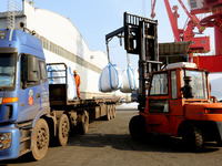 Dock workers are loading fertilizer that has been unloaded from a cargo ship at the port of Lianyungang, in Jiangsu Province, China, on Febr...