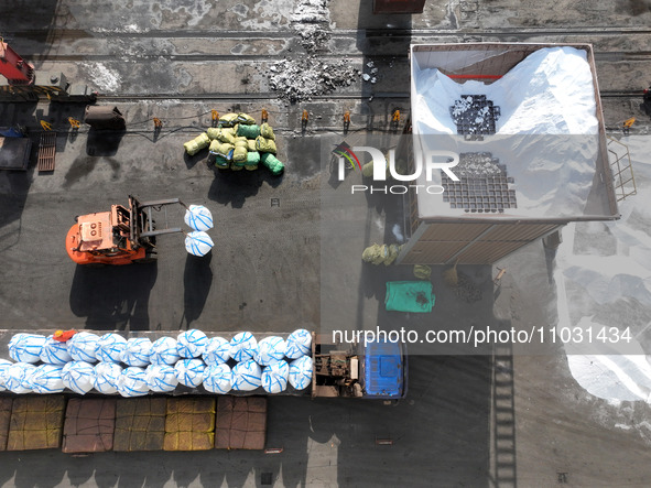 Dock workers are loading fertilizer that has been unloaded from a cargo ship at the port of Lianyungang, in Jiangsu Province, China, on Febr...