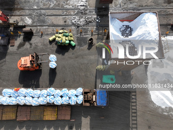 Dock workers are loading fertilizer that has been unloaded from a cargo ship at the port of Lianyungang, in Jiangsu Province, China, on Febr...