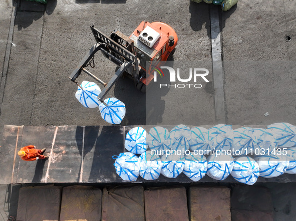 Dock workers are loading fertilizer that has been unloaded from a cargo ship at the port of Lianyungang, in Jiangsu Province, China, on Febr...