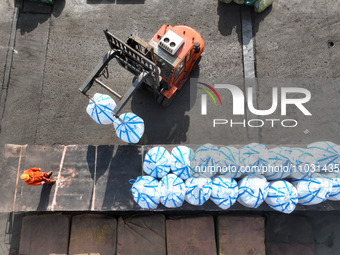 Dock workers are loading fertilizer that has been unloaded from a cargo ship at the port of Lianyungang, in Jiangsu Province, China, on Febr...