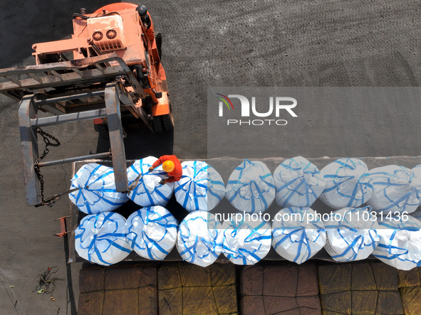 Dock workers are loading fertilizer that has been unloaded from a cargo ship at the port of Lianyungang, in Jiangsu Province, China, on Febr...