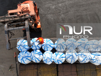 Dock workers are loading fertilizer that has been unloaded from a cargo ship at the port of Lianyungang, in Jiangsu Province, China, on Febr...