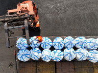 Dock workers are loading fertilizer that has been unloaded from a cargo ship at the port of Lianyungang, in Jiangsu Province, China, on Febr...