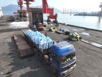 Dock workers are loading fertilizer that has been unloaded from a cargo ship at the port of Lianyungang, in Jiangsu Province, China, on Febr...