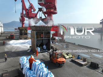 Dock workers are loading fertilizer that has been unloaded from a cargo ship at the port of Lianyungang, in Jiangsu Province, China, on Febr...