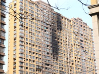 The facade of a high-rise building is blackened after a fire in the Mingshang Xiyuan residential area in the Yuhuatai district, in Nanjing,...