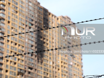 The facade of a high-rise building is blackened after a fire in the Mingshang Xiyuan residential area in the Yuhuatai district, in Nanjing,...