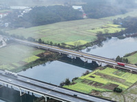 Fields of rapeseed flowers are blooming and mingling with villages, rivers, distant mountains, and roads in Yongzhou, Hunan Province, China,...