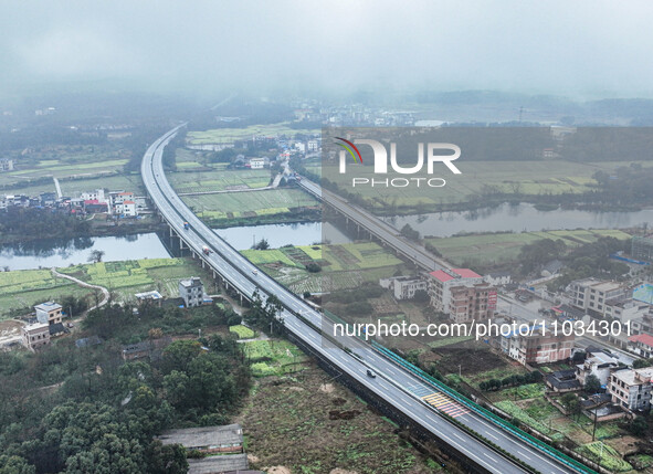 Fields of rapeseed flowers are blooming and mingling with villages, rivers, distant mountains, and roads in Yongzhou, Hunan Province, China,...