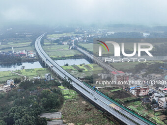 Fields of rapeseed flowers are blooming and mingling with villages, rivers, distant mountains, and roads in Yongzhou, Hunan Province, China,...