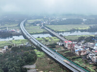 Fields of rapeseed flowers are blooming and mingling with villages, rivers, distant mountains, and roads in Yongzhou, Hunan Province, China,...