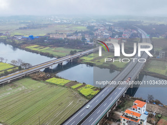 Fields of rapeseed flowers are blooming and mingling with villages, rivers, distant mountains, and roads in Yongzhou, Hunan Province, China,...