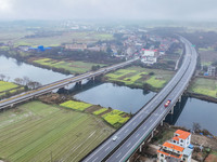 Fields of rapeseed flowers are blooming and mingling with villages, rivers, distant mountains, and roads in Yongzhou, Hunan Province, China,...