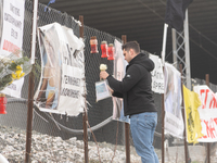 A relative of a 20-year-old woman who was fatally struck by a train is leaving a white rose on the wire fence beside the tracks, in Tempi Th...