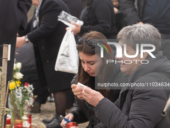 The mother of a young girl is crying in front of the sign that reads her deceased daughter's name, in Tempi Thessaly, Greece, on on February...