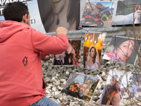 The husband of a young woman who was killed in a crash is hanging photos of her on the rail fence, in Tempi Thessaly, Greece, on on February...