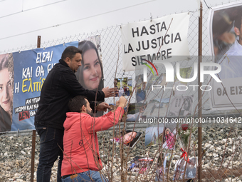 The husband of a young woman who was killed in a crash is hanging photos of her on the rail fence, in Tempi Thessaly, Greece, on on February...