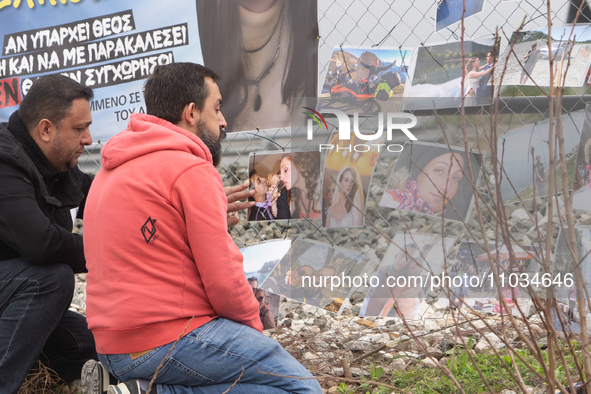 The husband of a young woman who was killed in a crash is hanging photos of her on the rail fence, in Tempi Thessaly, Greece, on on February...