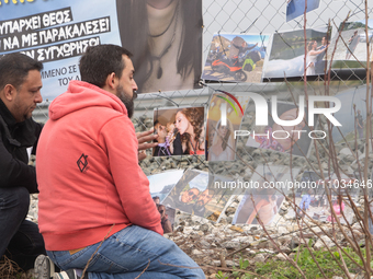 The husband of a young woman who was killed in a crash is hanging photos of her on the rail fence, in Tempi Thessaly, Greece, on on February...