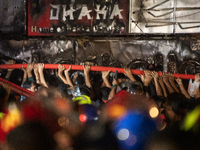 Volunteers are holding a water pipe after a fire in a multi-storey building in Dhaka, Bangladesh, on February 29, 2024. At least 43 people h...