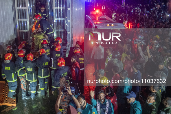 Firefighters are carrying an injured person during a rescue operation after a fire broke out in a commercial building in Dhaka, Bangladesh,...