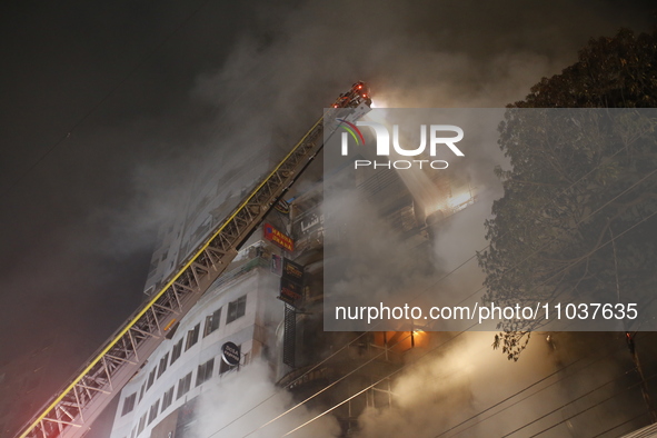 Firefighters are working to extinguish a fire in a commercial building that has killed at least 43 people in Dhaka, Bangladesh, on February...