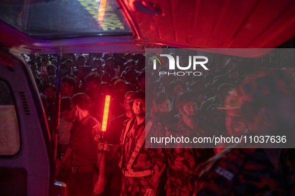 A BGB personnel is reacting to the camera while on duty at the site of a fire that broke out in a commercial building in Dhaka, Bangladesh,...