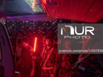 A BGB personnel is reacting to the camera while on duty at the site of a fire that broke out in a commercial building in Dhaka, Bangladesh,...