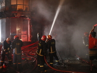 Firefighters are working to extinguish a fire in a commercial building that has killed at least 43 people in Dhaka, Bangladesh, on February...