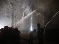 Firefighters are working to extinguish a fire in a commercial building that has killed at least 43 people in Dhaka, Bangladesh, on February...