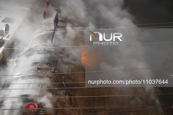 Firefighters are working to extinguish a fire in a commercial building that has killed at least 43 people in Dhaka, Bangladesh, on February...