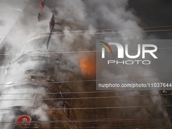 Firefighters are working to extinguish a fire in a commercial building that has killed at least 43 people in Dhaka, Bangladesh, on February...