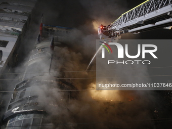 Firefighters are working to extinguish a fire in a commercial building that has killed at least 43 people in Dhaka, Bangladesh, on February...