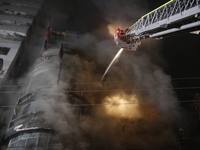 Firefighters are working to extinguish a fire in a commercial building that has killed at least 43 people in Dhaka, Bangladesh, on February...