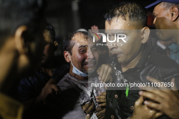 A man is reacting during rescue operations following a fire in a commercial building that has killed at least 43 people in Dhaka, Bangladesh...