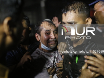 A man is reacting during rescue operations following a fire in a commercial building that has killed at least 43 people in Dhaka, Bangladesh...