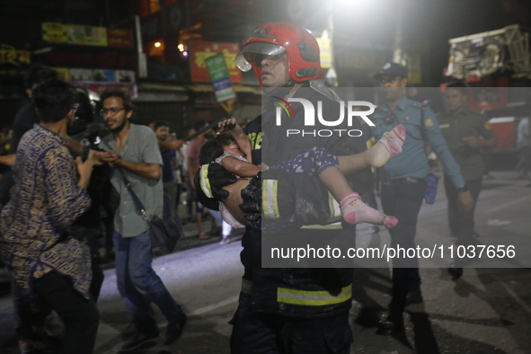 A firefighter is carrying an injured person during rescue operations following a fire in a commercial building in Dhaka, Bangladesh, on Febr...