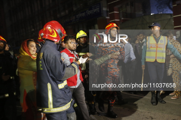 Firefighters are carrying an injured person during rescue operations following a fire in a commercial building that has killed at least 43 p...